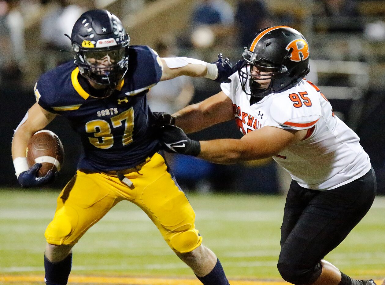 Highland Park High School running back Jay Cox (37) tries to escape Rockwall High School...