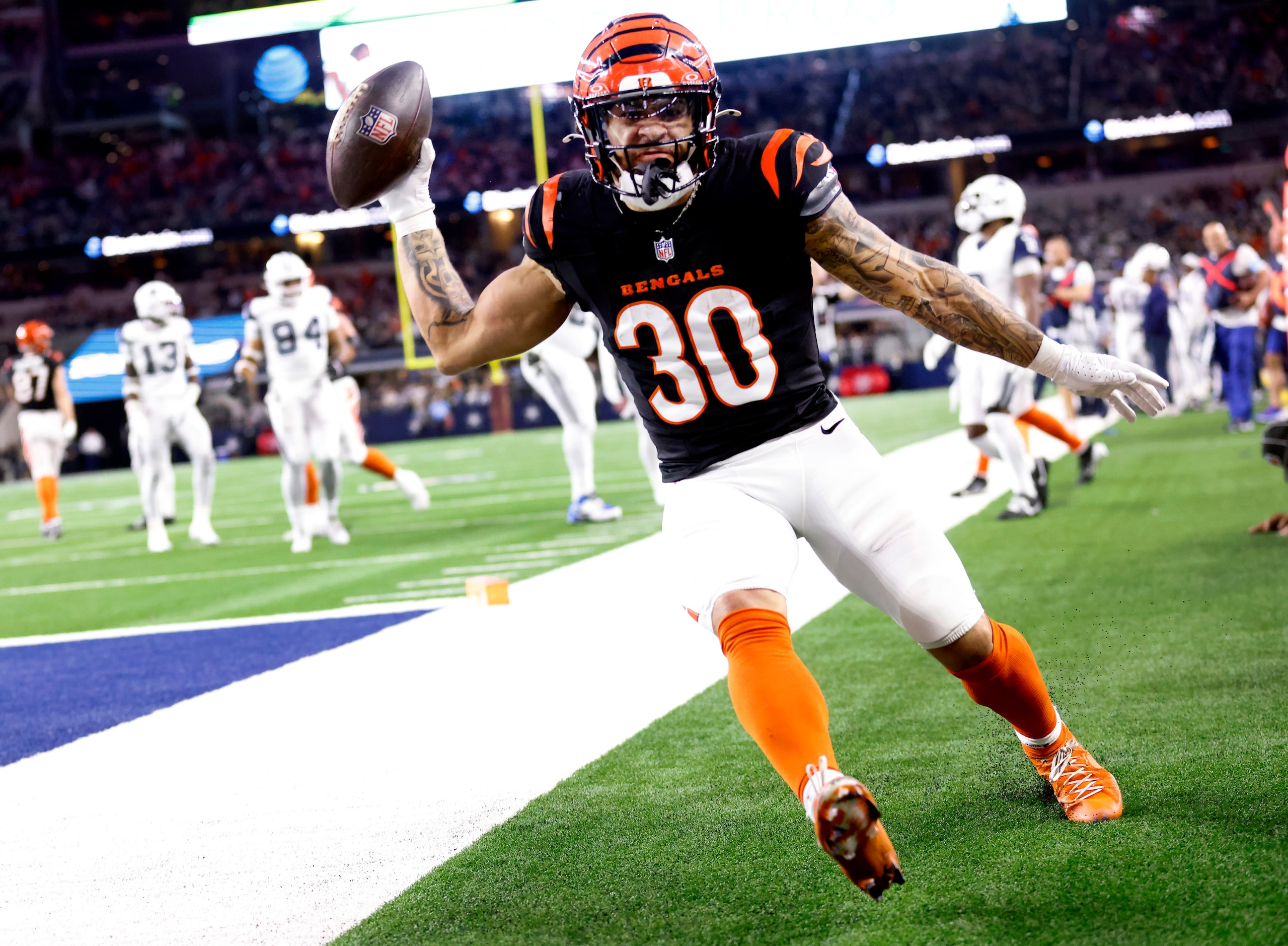 Cincinnati Bengals running back Chase Brown (30) fires the football as he celebrates a...