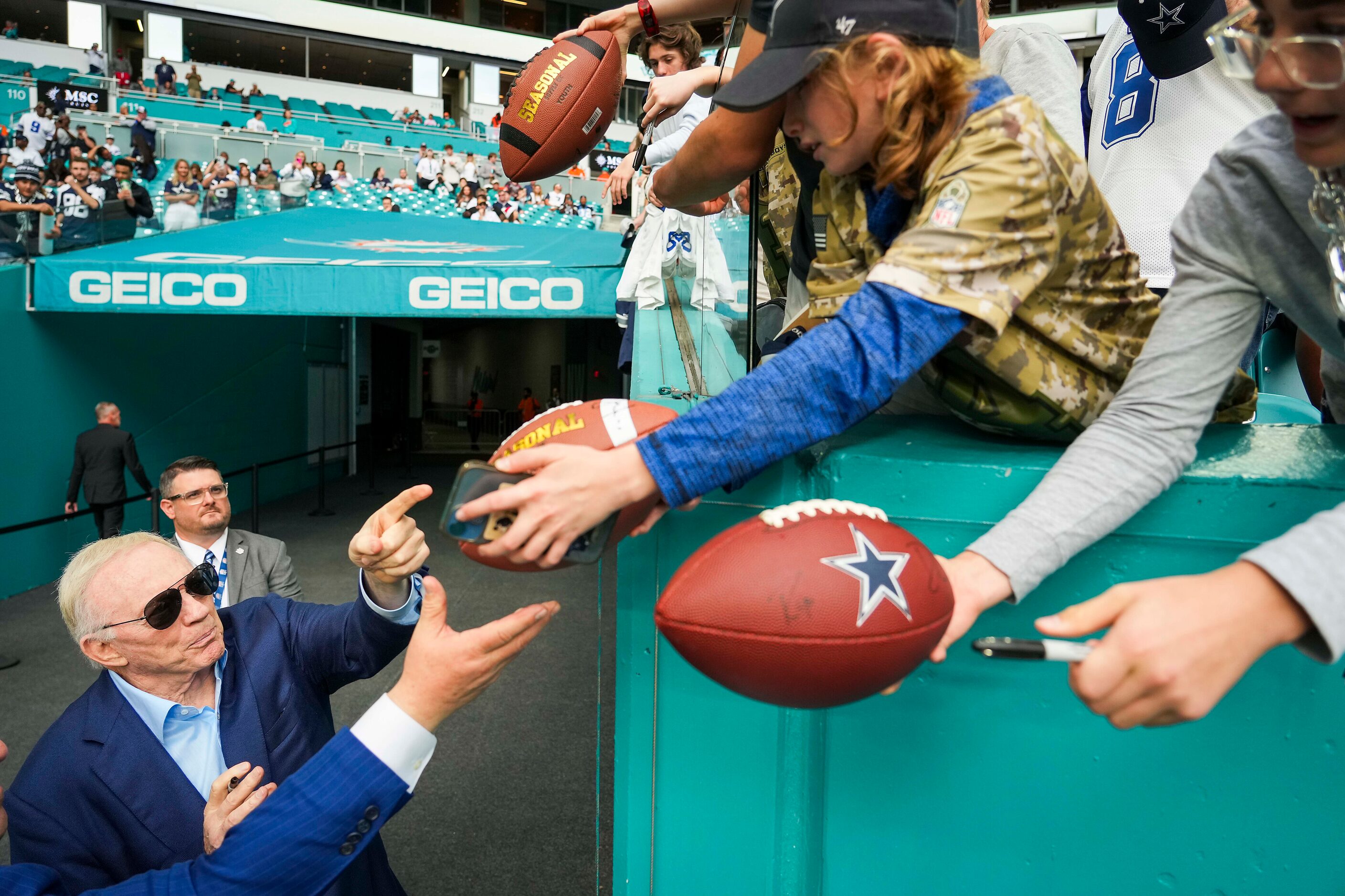 Dallas Cowboys owner and general manager Jerry Jones signs autographs before an NFL football...