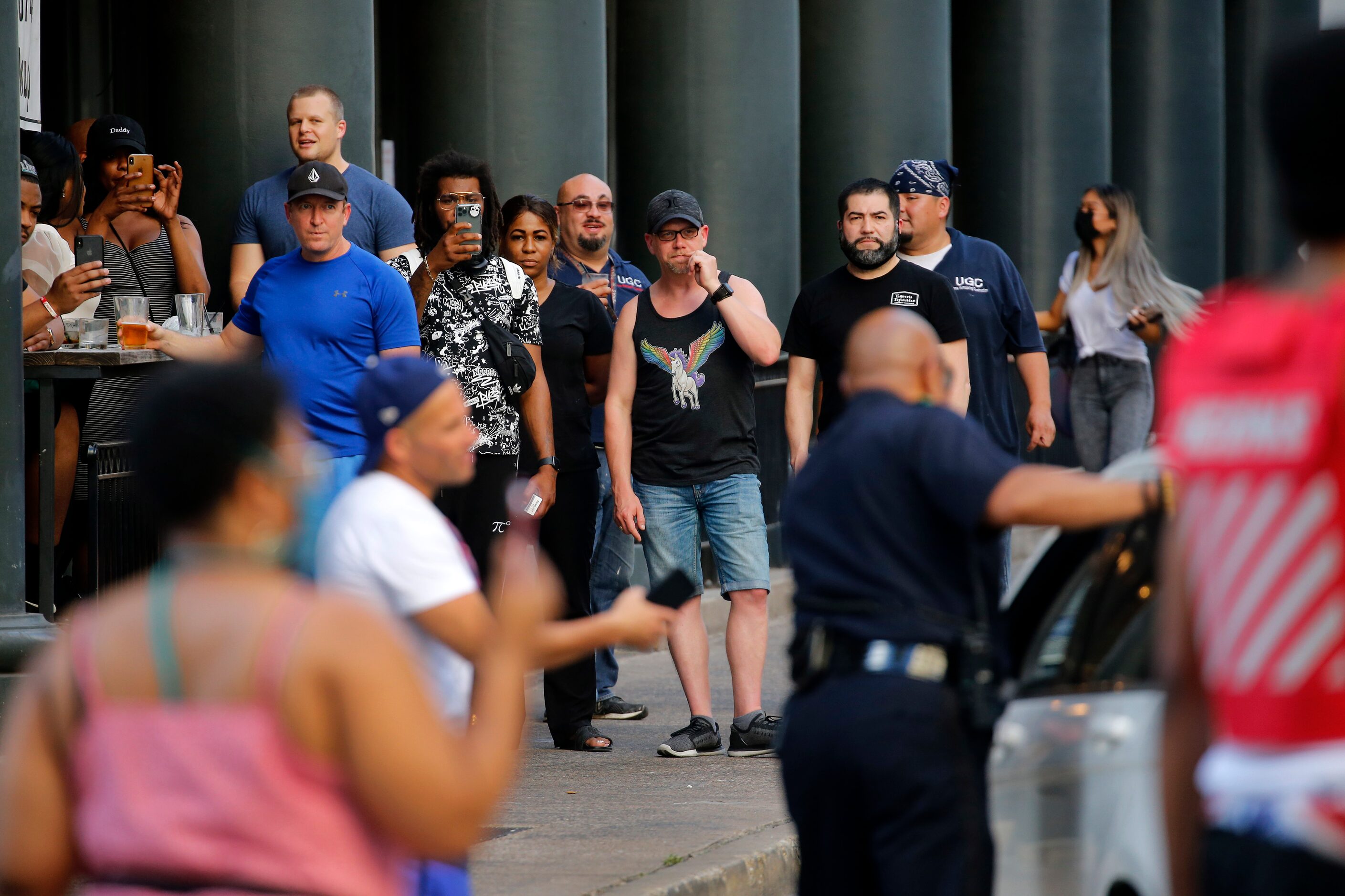 Restaurant and bar patrons come out on the sidewalk to see a motorist who tried to get...