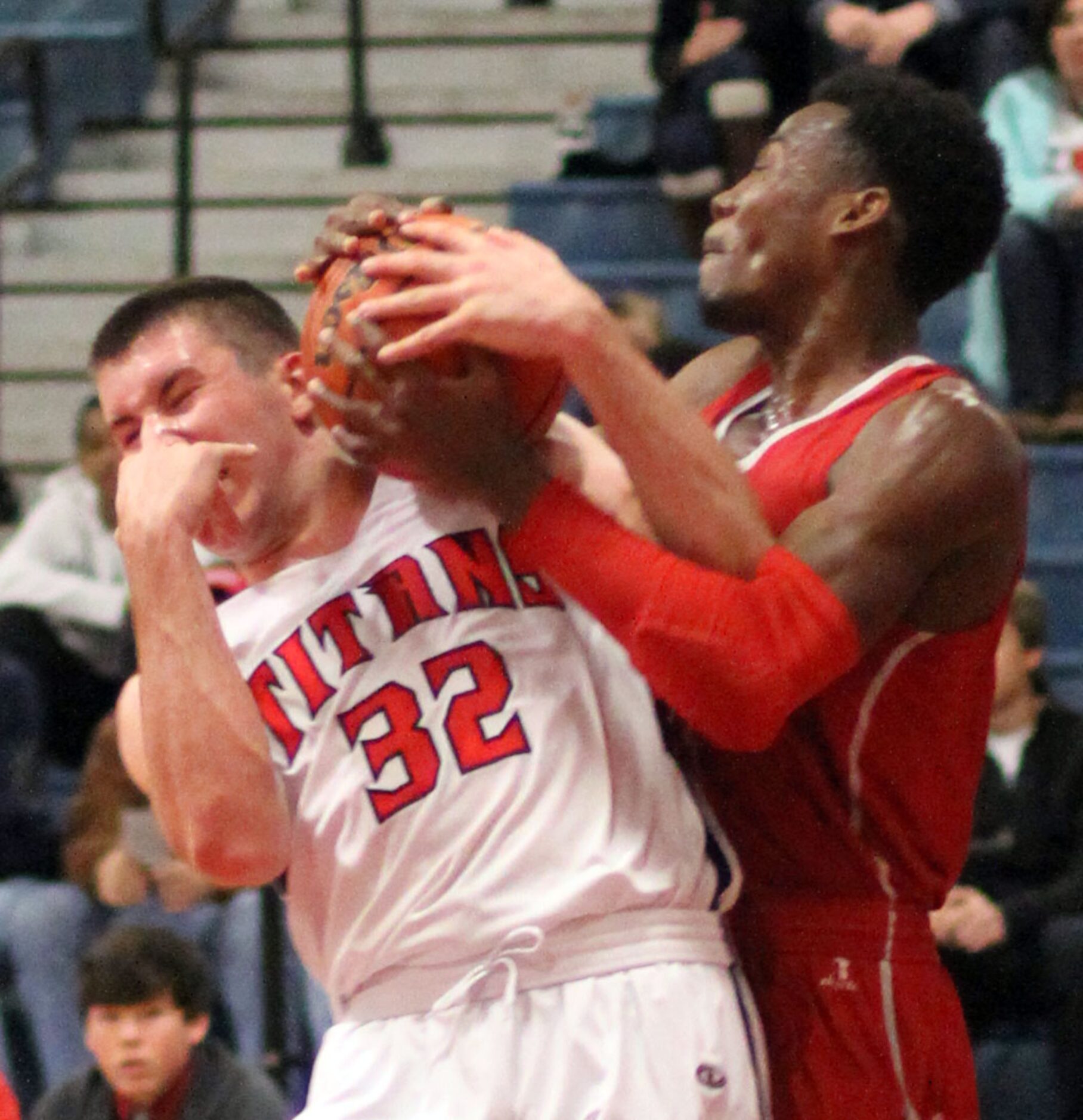 Frisco Centennial forward John Robbins (32) winces as he battles with Woodrow Wilson's...