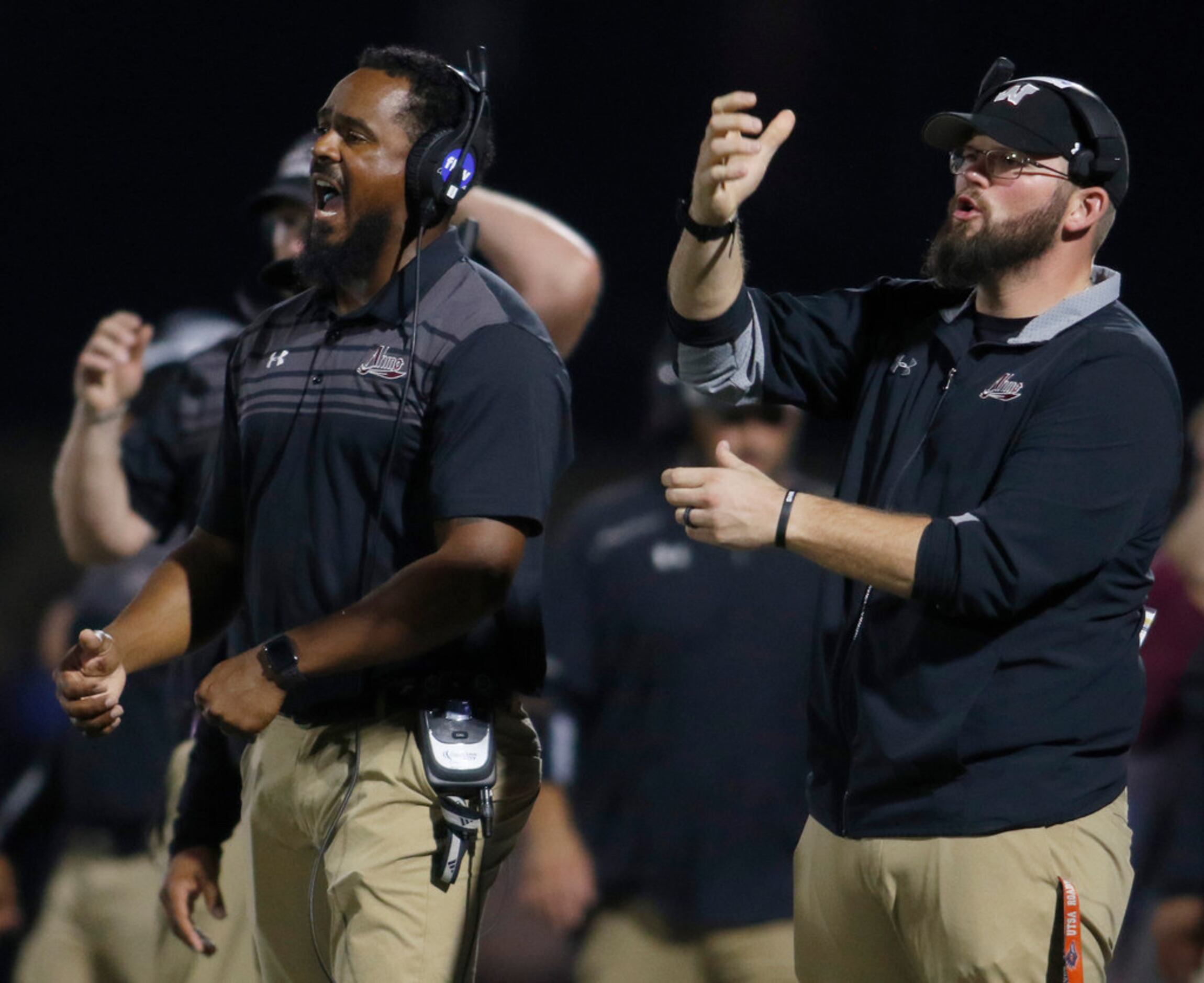 Members of the Wylie coaching staff send in an offensive play from the team bench area...