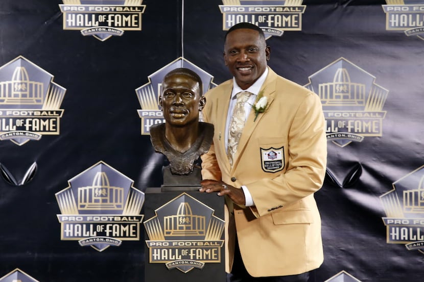 Former NFL player Tim Brown poses with his bust during an induction ceremony at the Pro...