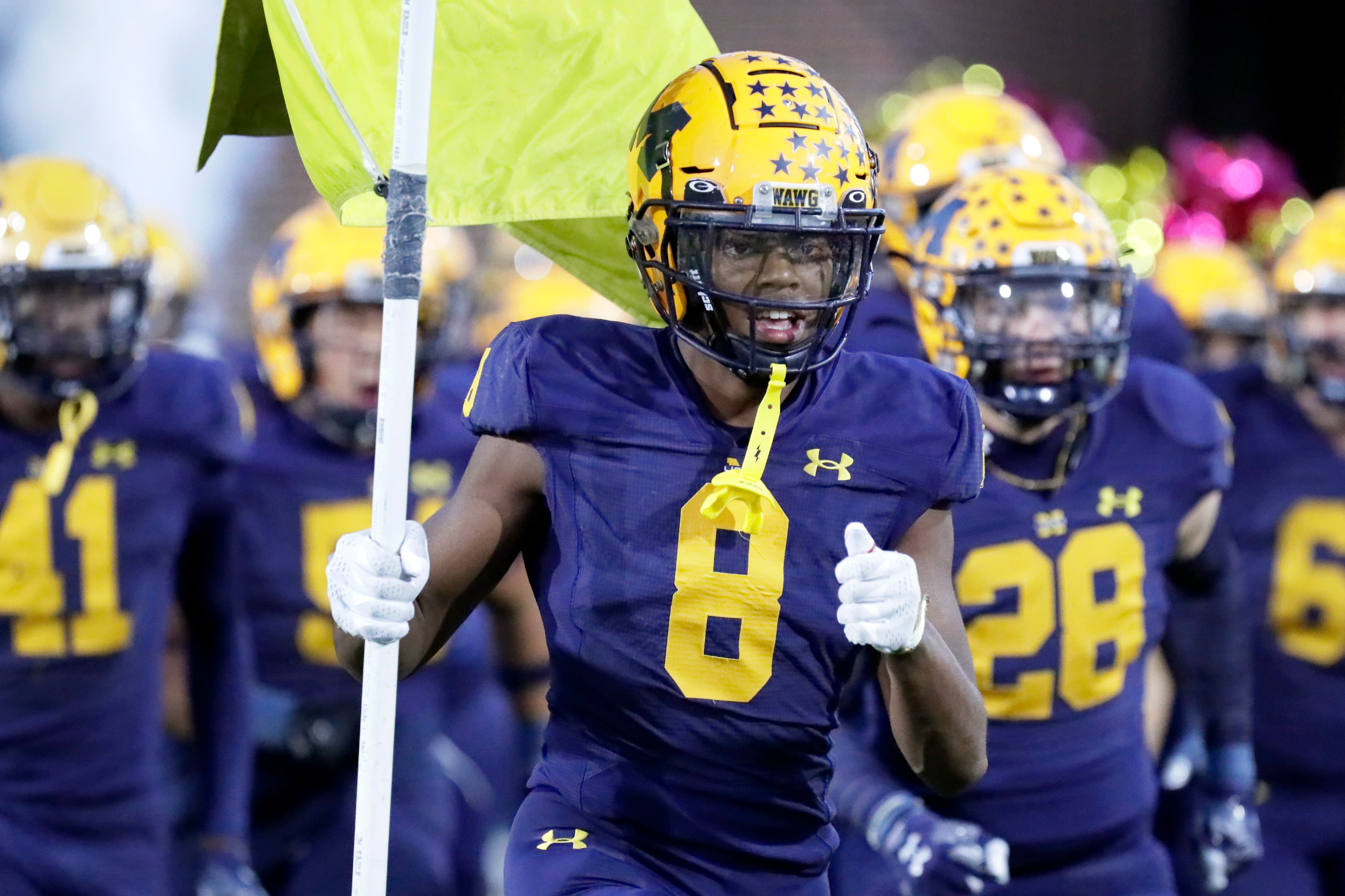 McKinney High School cornerback Ashton McShane (8) leads his team onto the field before...