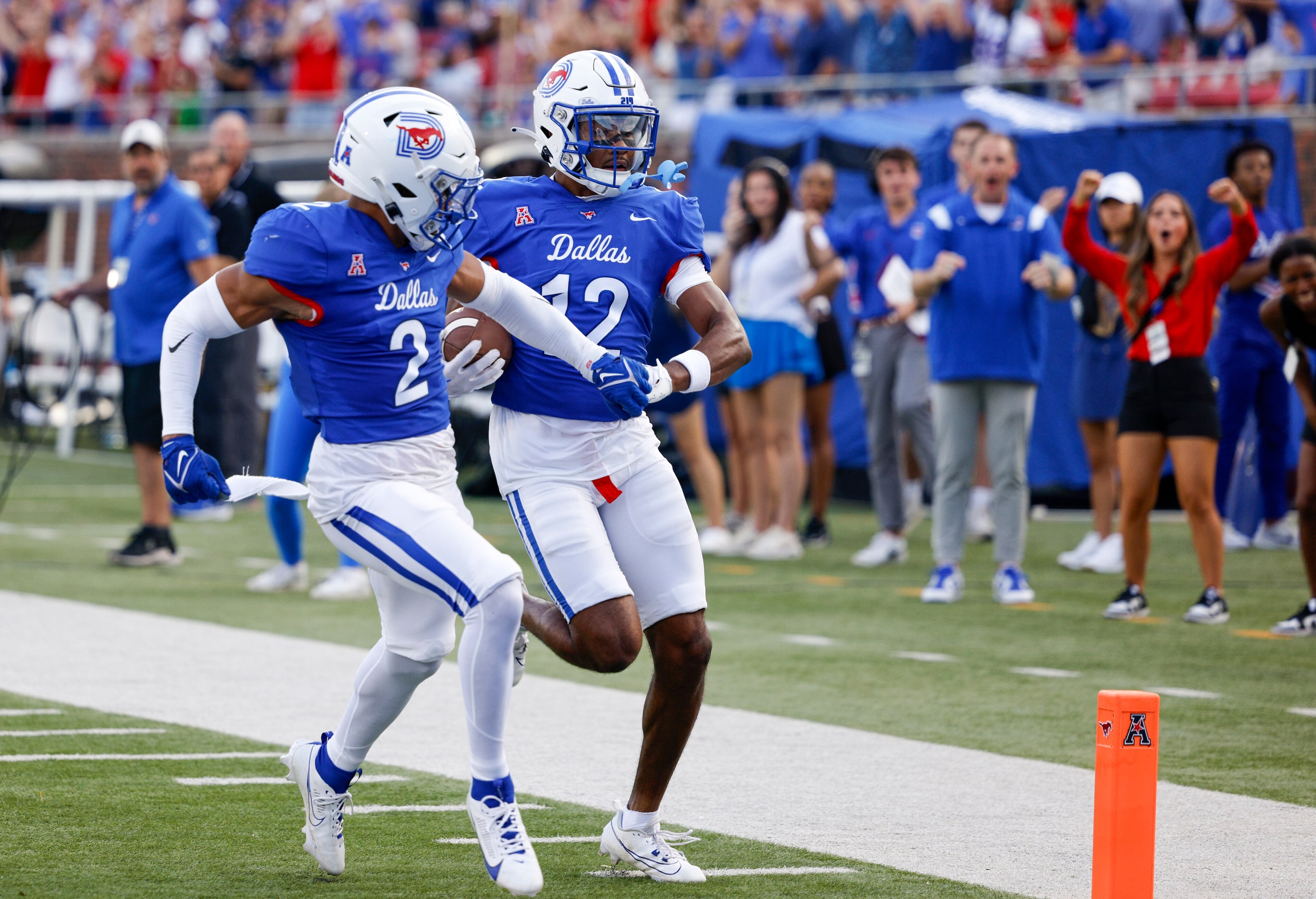 SMU cornerback Chris Megginson (12) holds hands with SMU safety Jonathan McGill (2) as he...