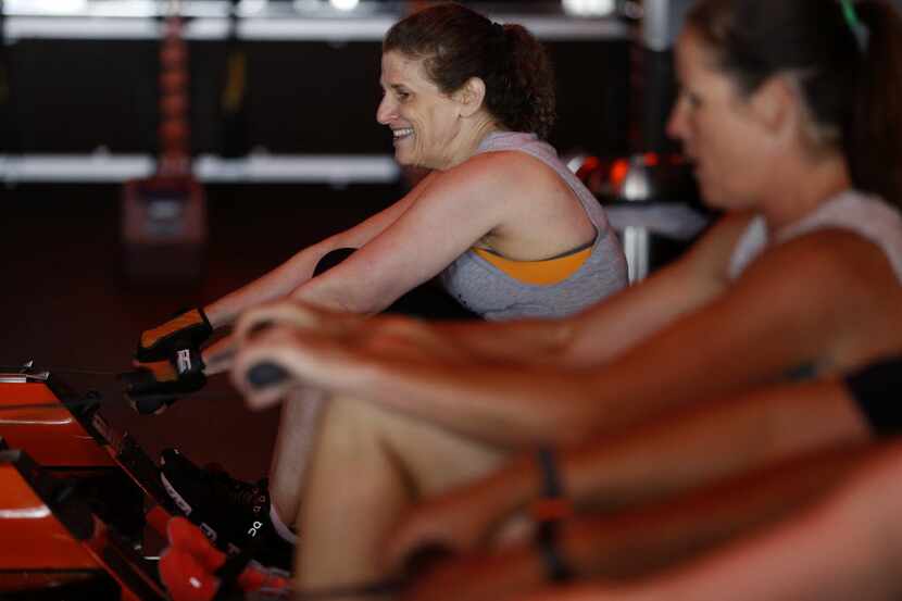 Meryl Evans (left) works out on the rowing machine at Orangetheory Fitness in Plano.