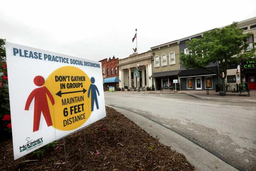 In McKinney's town square, a sign promotes social distancing. The mayor this week ordered...