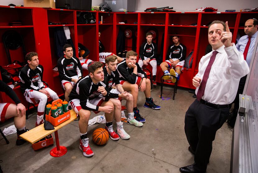Yavneh Head Coach David Zimmerman, right, talks strategy with his team in the locker room...