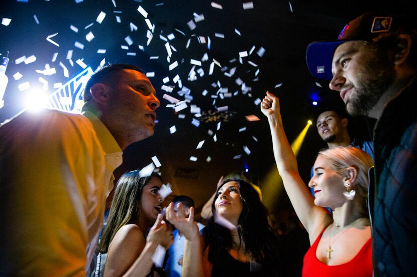 Gezebel Marina, second left, Alex Banister, and Devin Rogers dance as confetti falls to the...