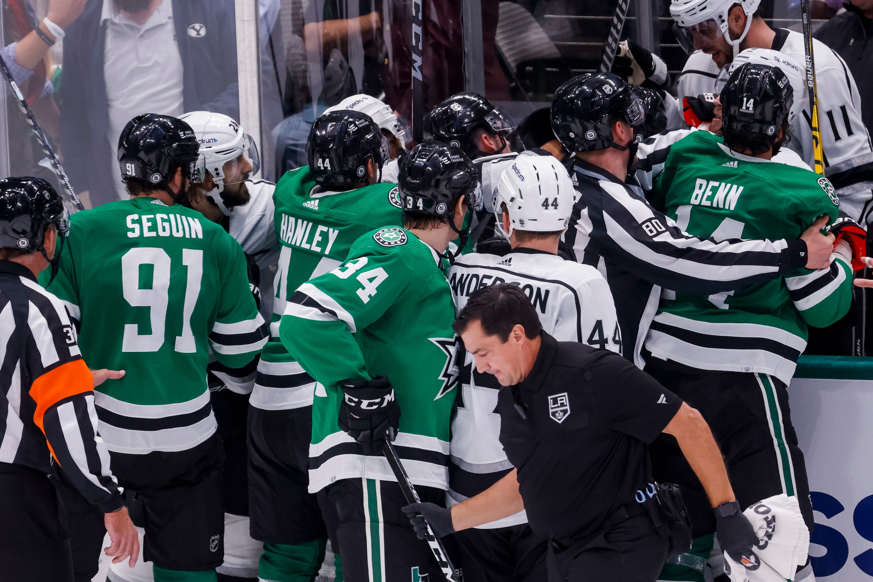 Referees pull players from a fight during the second period of a Dallas Stars home opener...