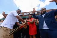 Founder Antoria Gillon, center, cuts the ribbon with husband Gabriel Evans, left, as...
