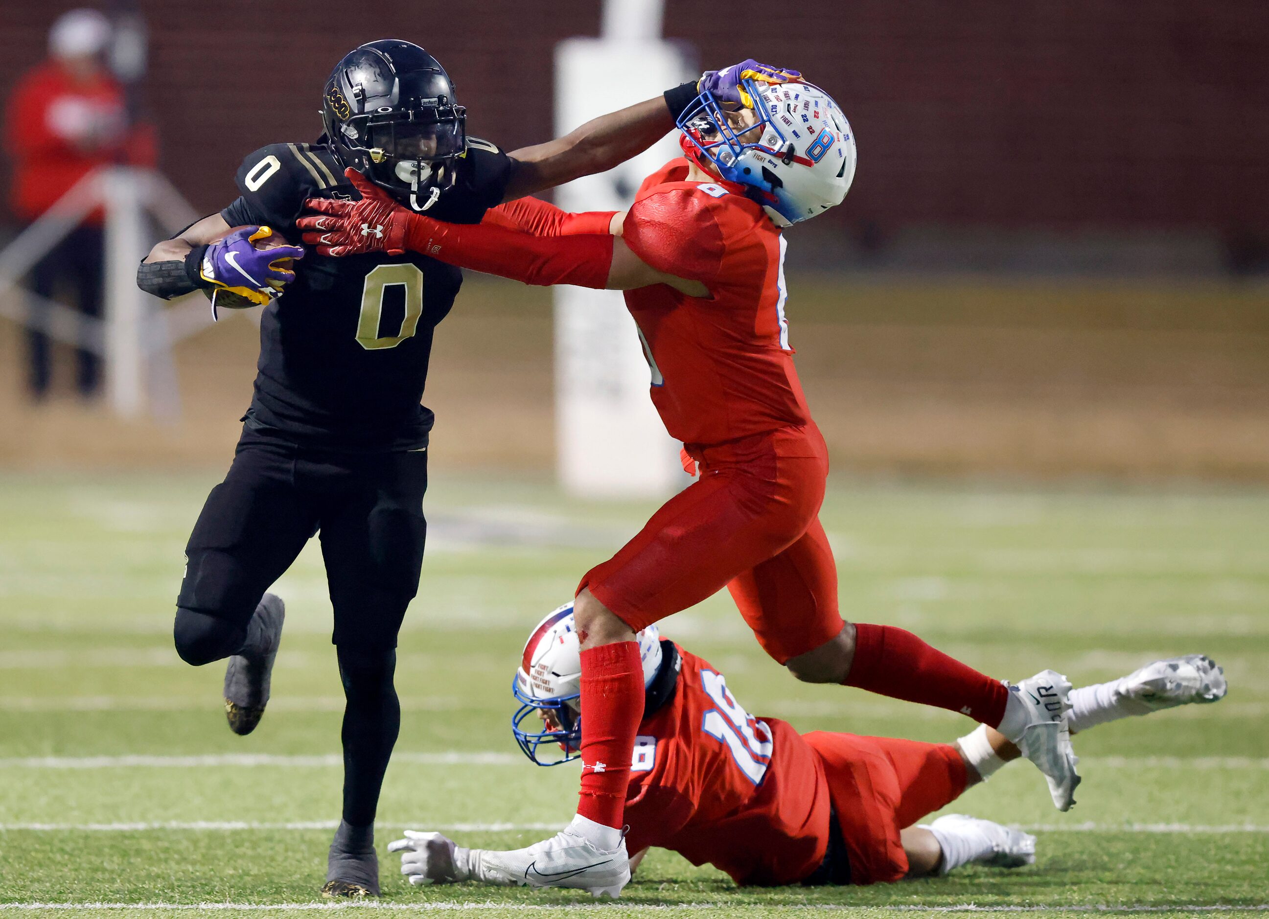 South Oak Cliff’s Jayvon Thomas gives a stiff arm to Midlothian Heritage’s Solomon Hopkins...