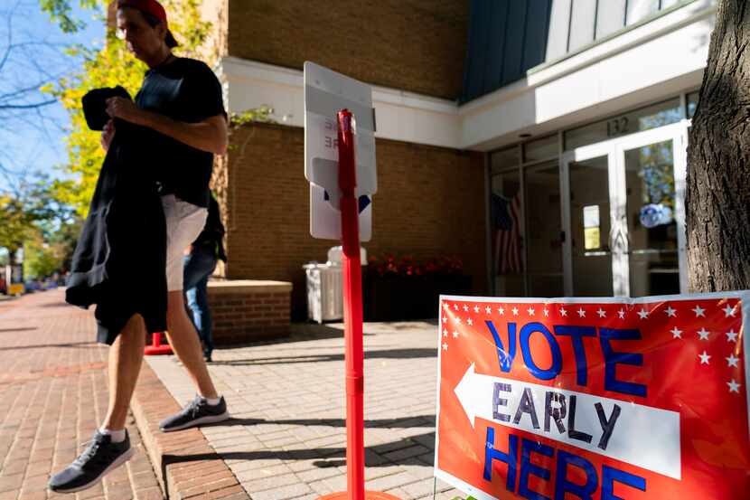 An early voter leaves a voting location in Alexandria, Va., Monday, Sept. 26, 2022....