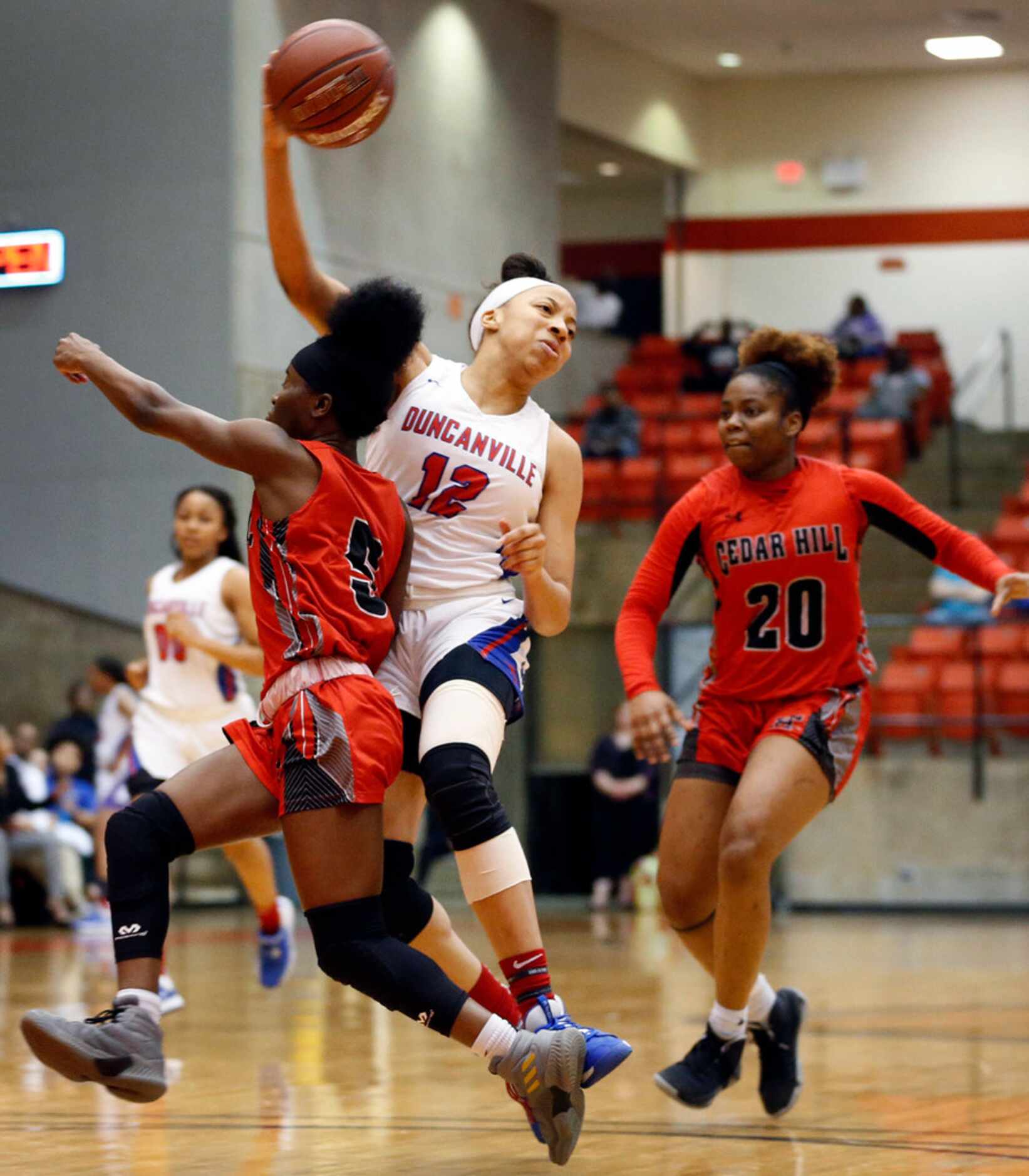 Duncanville's Zaria Rufus (12) passes the ball off to a teammate as she's cutoff by Cedar...