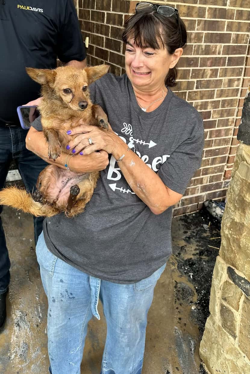 Janice Holsteen holds Ruby in her arms shortly after the dog was found alive following a...