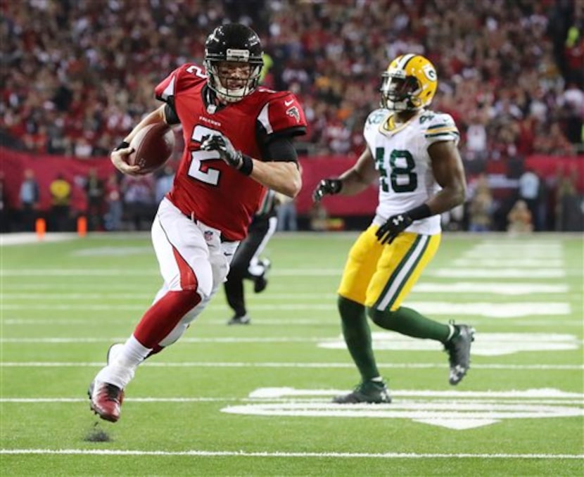 Matt Ryan, quarterback de los Falcons de Atlanta, acarrea el ovoide a la zona de anotación...