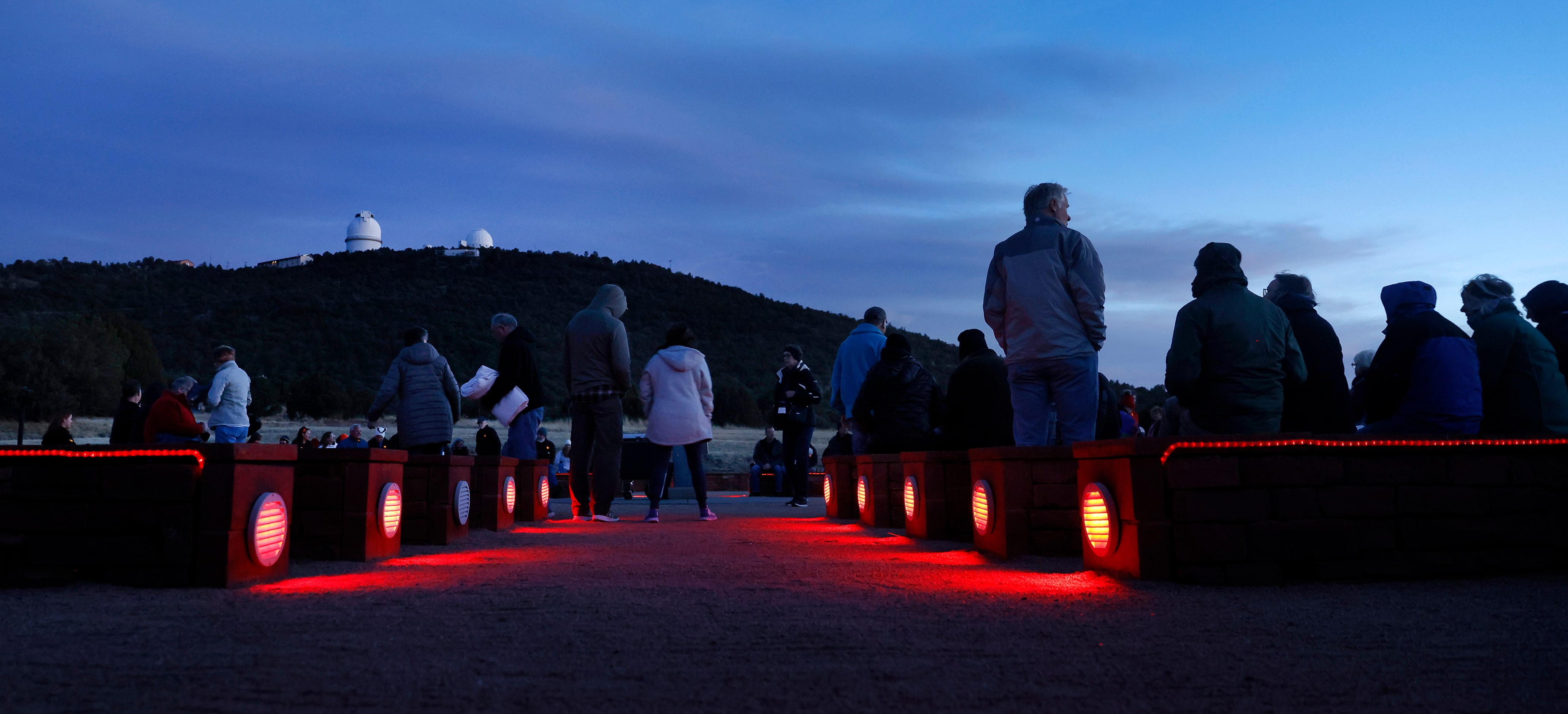 Visitors gathered in the red-lighted amphitheater for a star party at the University of...