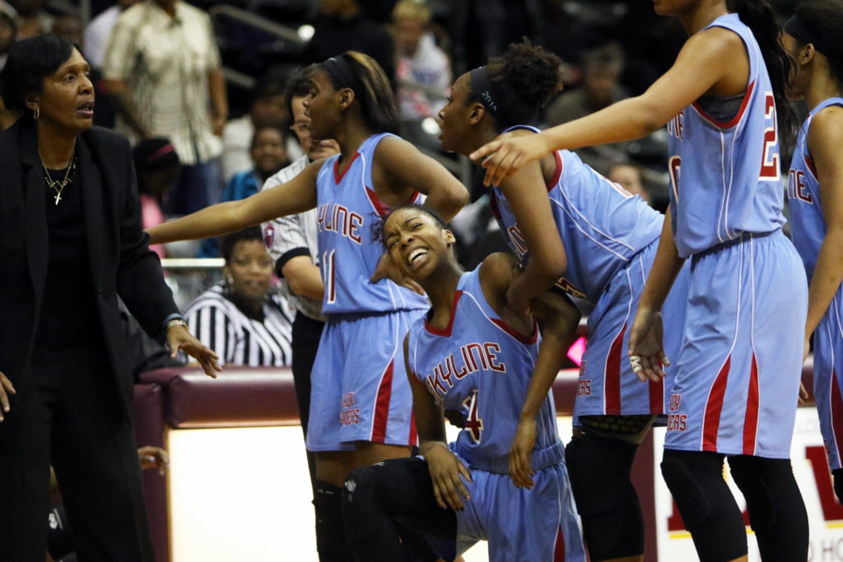 Skyline guard Raven Johnson (center) is helped by teammates after an injury in the second...