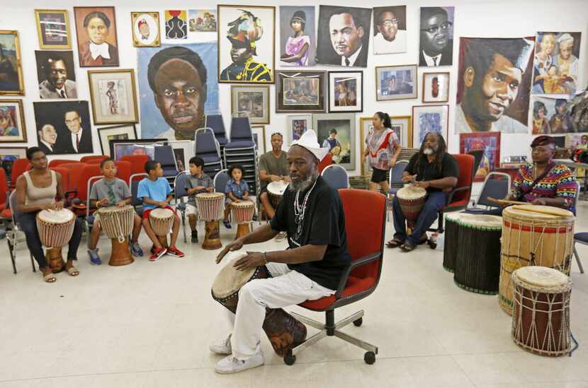 Community leader Baba Ifayomi Amuson (center) teaches how to play drums during a Community...