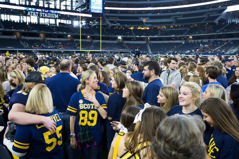 Highland Park fans cover the field following their team's victory over Temple in the UIL...