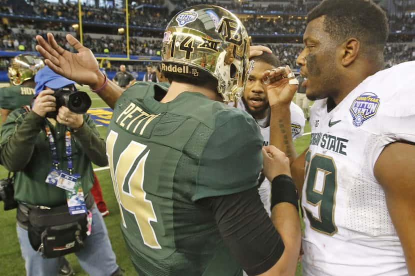 Baylor quarterback Bryce Petty (14) receives encouragement from Michigan State's Shilique...