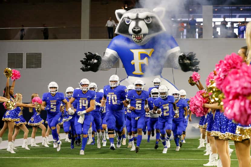 The Frisco football team takes the field before the first half of a high school football...