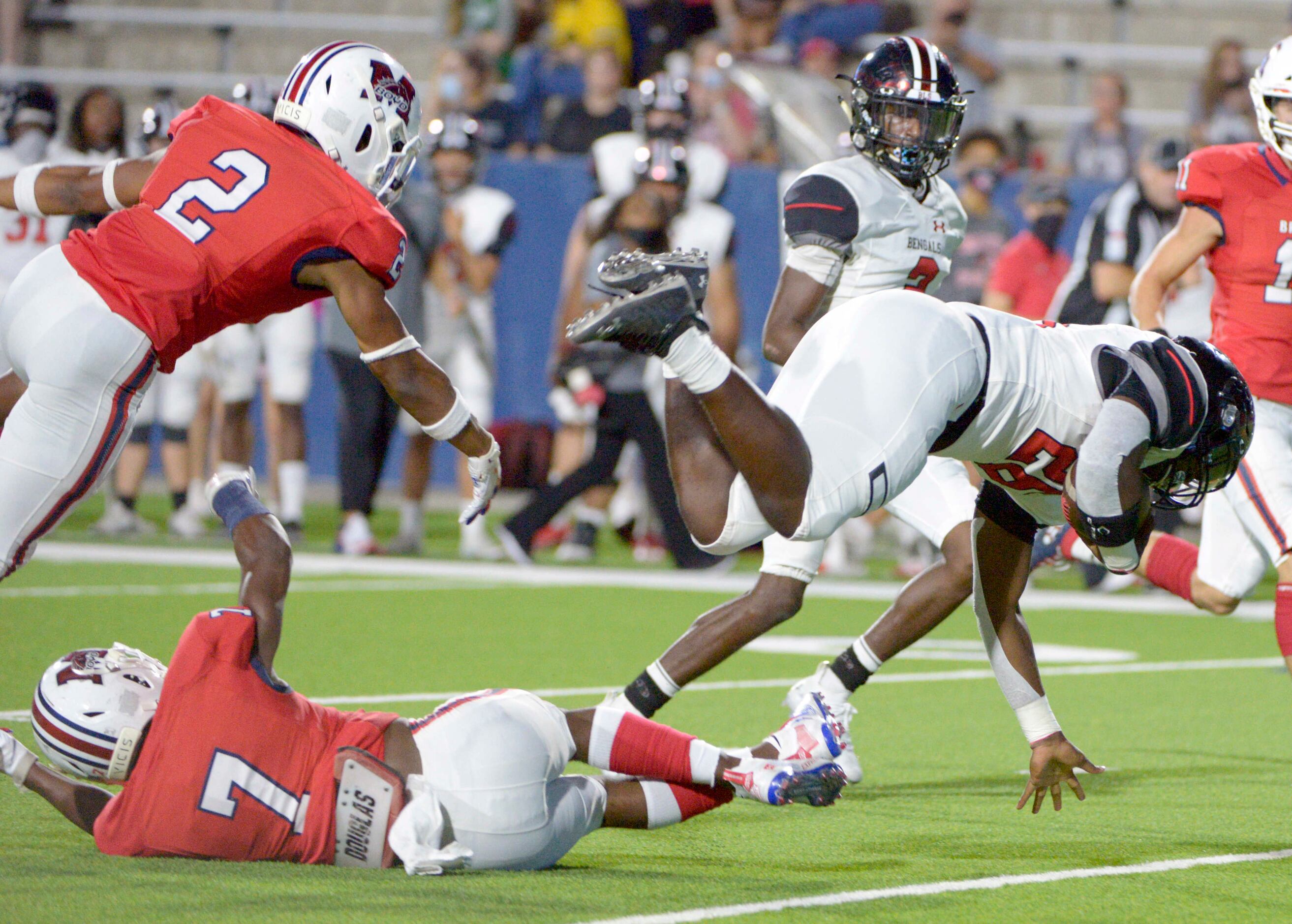 Denton Braswell’s Jamerion Sanford is upended by McKinney Boyd’s Peyton Shaw (7) and Ty...