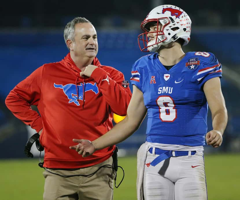 New Southern Methodist Mustangs head coach Sonny Dykes and quarterback Ben Hicks (8) speak...