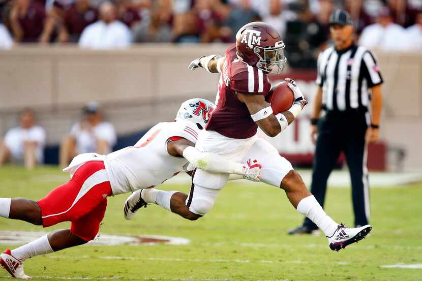 Texas A&M Aggies running back Trayveon Williams (5) is tripped up by Nicholls State Colonels...