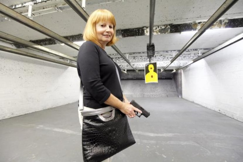 
Jean Rosandich holds a Glock at the Shooter Shop in West Allis, Wis., as she models a...