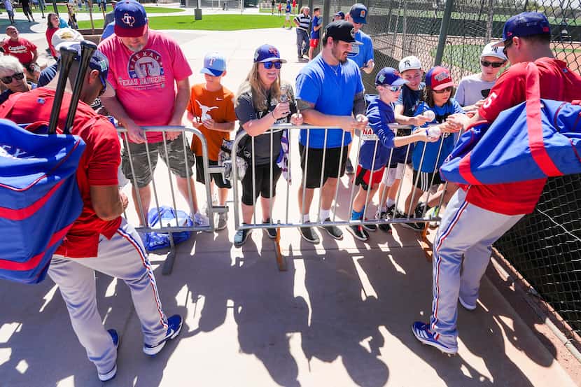Los jugadores de los Texas Rangers, Marcus Semien (izq) y Corey Seager, firman autógrafos a...