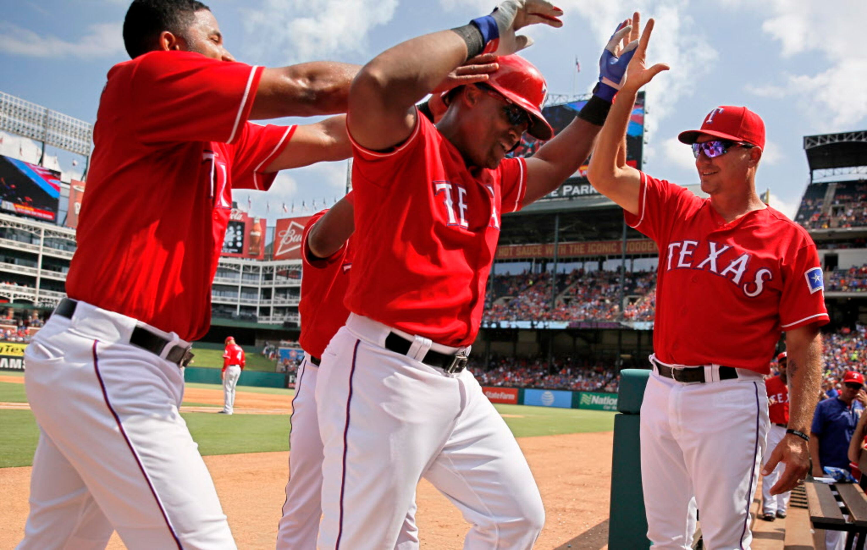 Teammates congratulate Texas Rangers third baseman Adrian Beltre as he scored a home run...