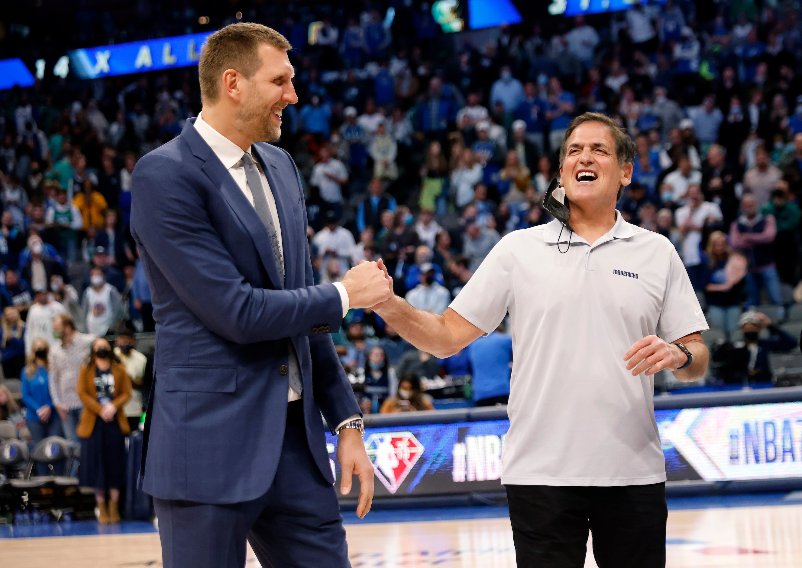 Former Dallas Mavericks All-Star Dirk Nowitzki (left) receives a fist bump from owner Mark...