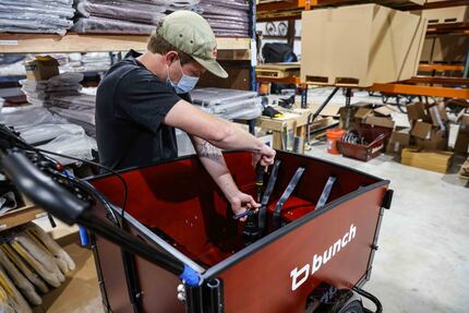 Logan Holland assembles a bike at Bunch Bikes in Denton on Wednesday, March 24, 2021. (Lola...