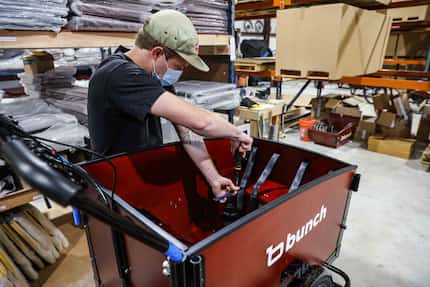 Logan Holland assembles a bike at Bunch Bikes in Denton on Wednesday, March 24, 2021. (Lola...