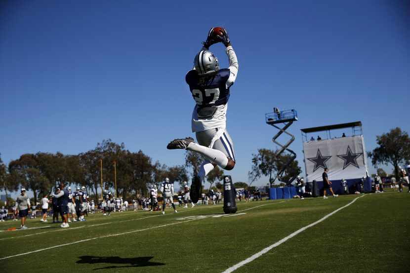 Dallas Cowboys free safety J.J. Wilcox (27) flies through the air to catch a pass during...