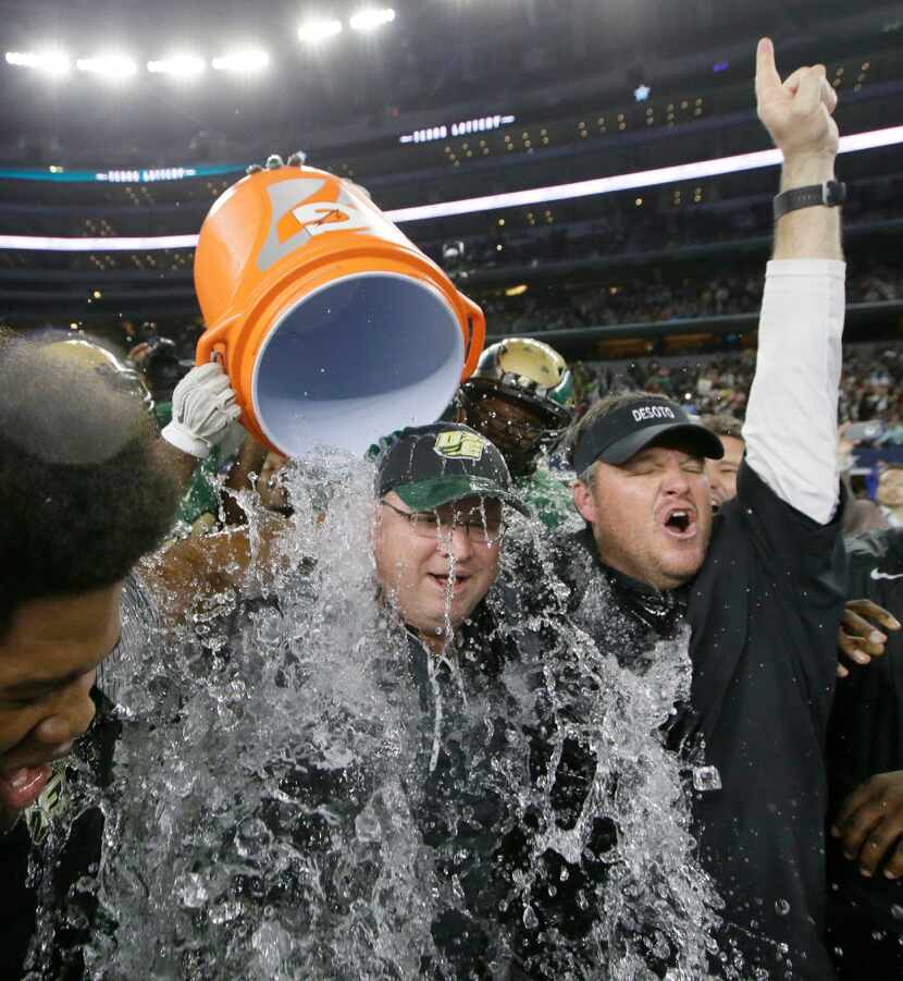 DeSoto head coach Todd Peterman, left, is doused with assistant coach Jeff Wigington as they...