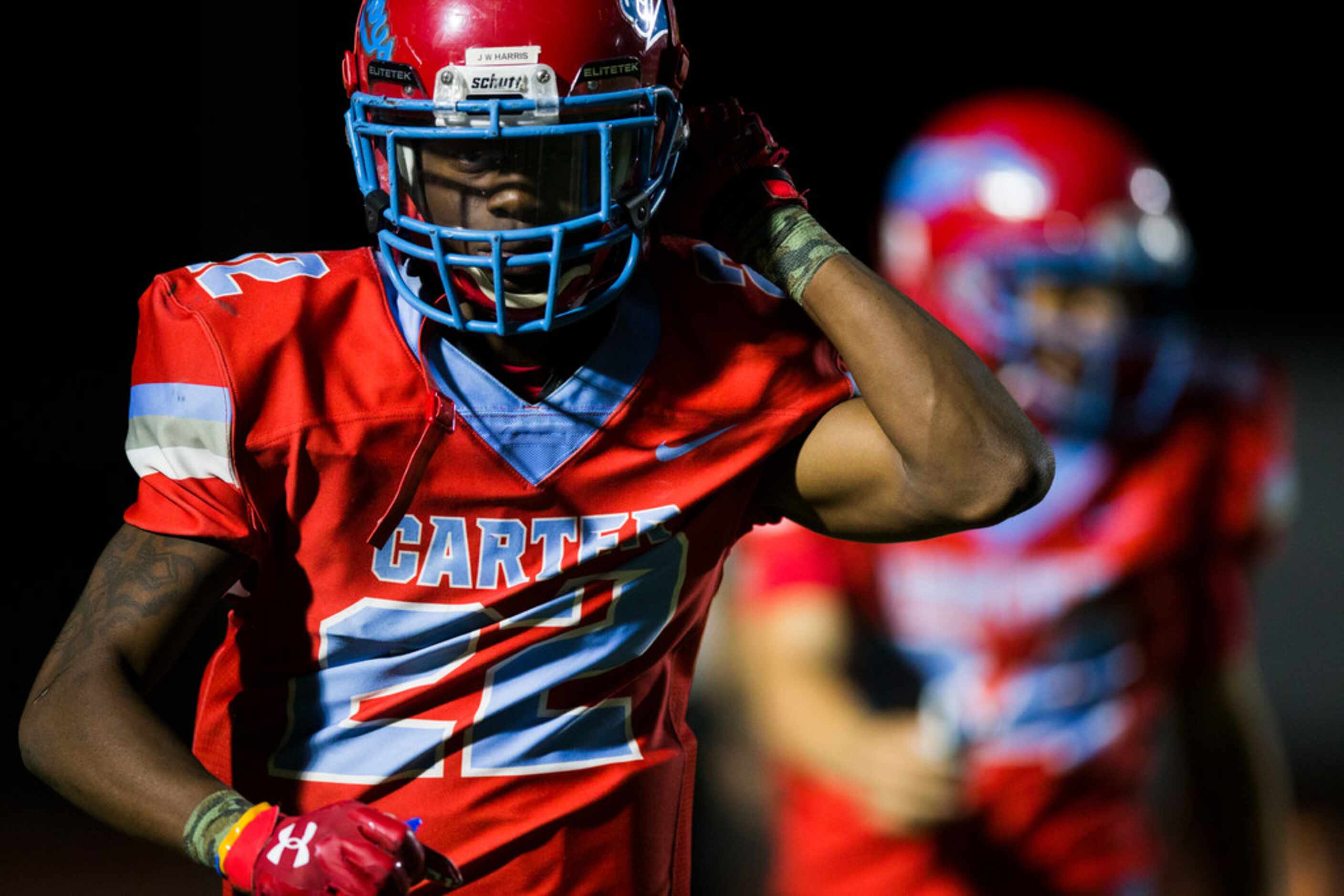 Carter running back Justise Wade-Harris (22) takes off his helmet as he runs to the sideline...