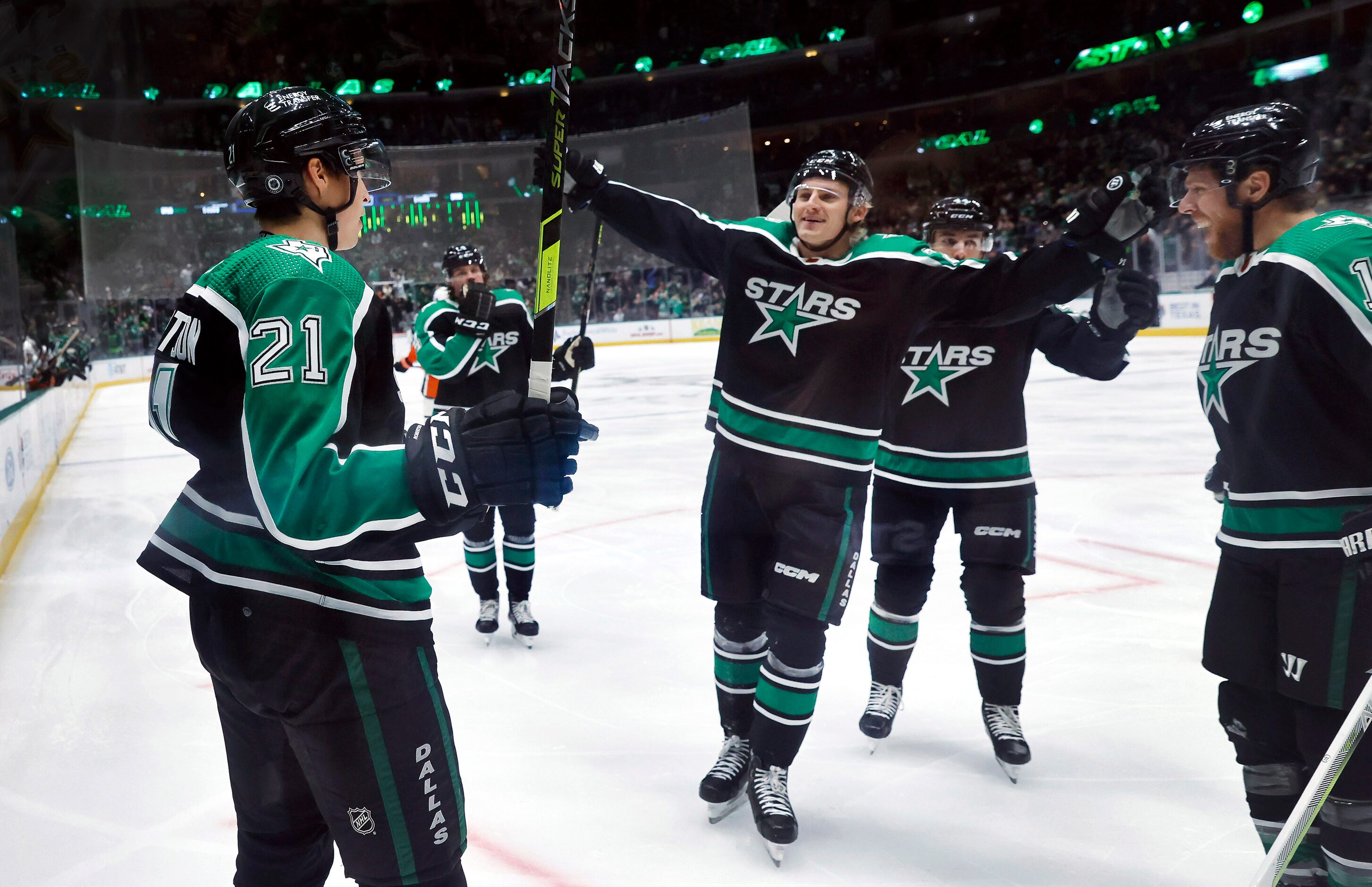 Dallas Stars left wing Jason Robertson (21) is congratulated by teammates after scoring a...