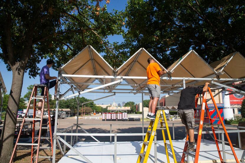 Workers install a tent at Fair Park in Dallas on Tuesday, August 20, 2019. The State Fair of...