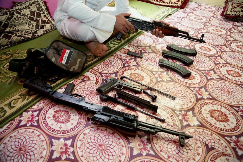 An Iraq weapon dealer cleans his weapon at his home in Baghdad, Iraq, Saturday, July 12,...