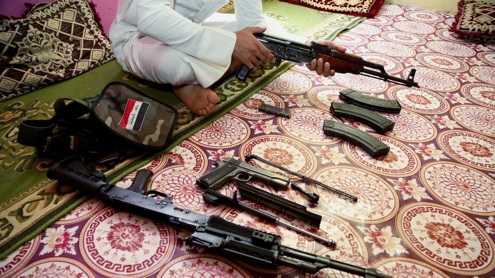 An Iraq weapon dealer cleans his weapon at his home in Baghdad, Iraq, Saturday, July 12,...