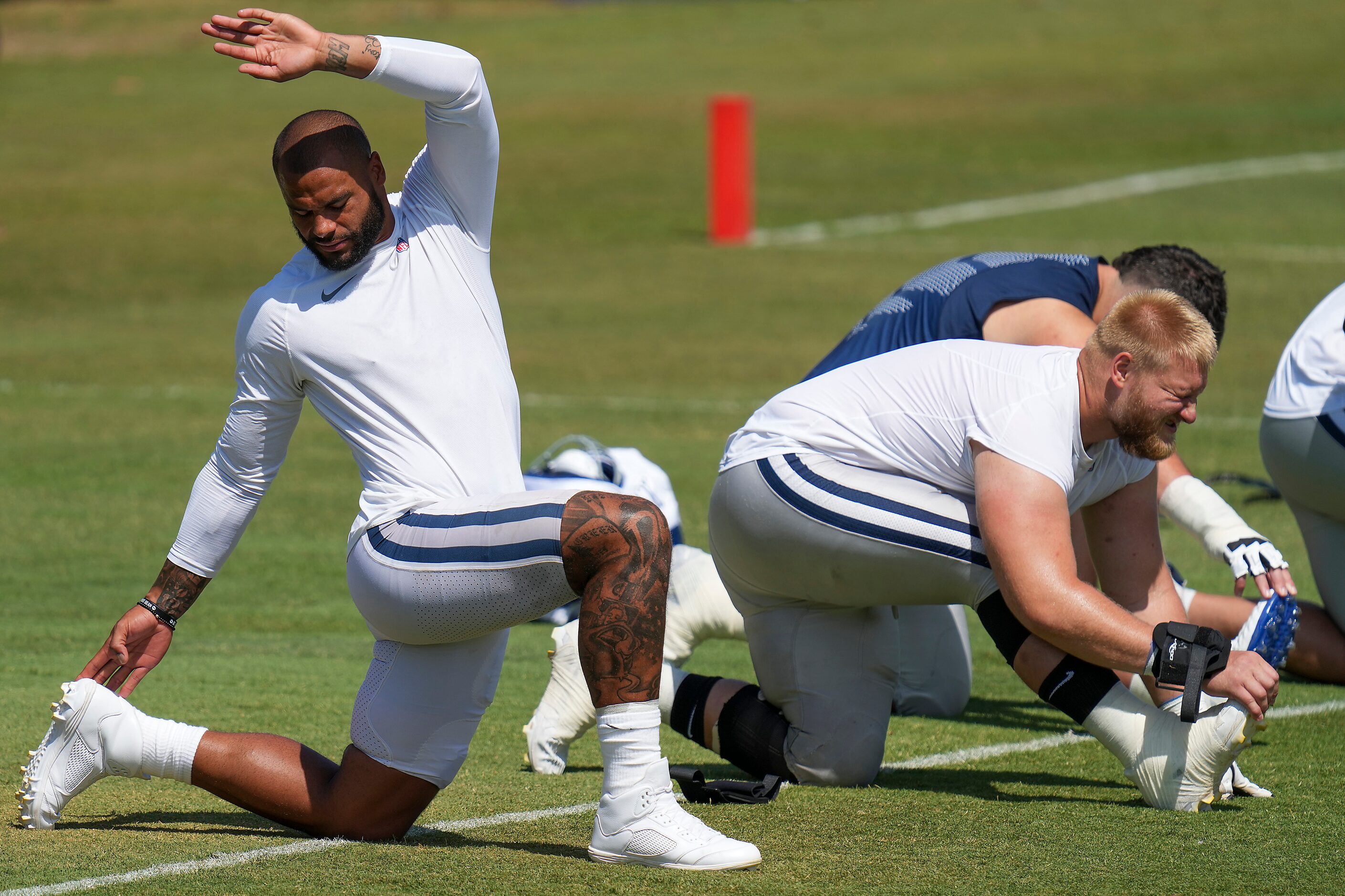 Dallas Cowboys quarterback Dak Prescott (left) and center Tyler Biadasz stretch during a...