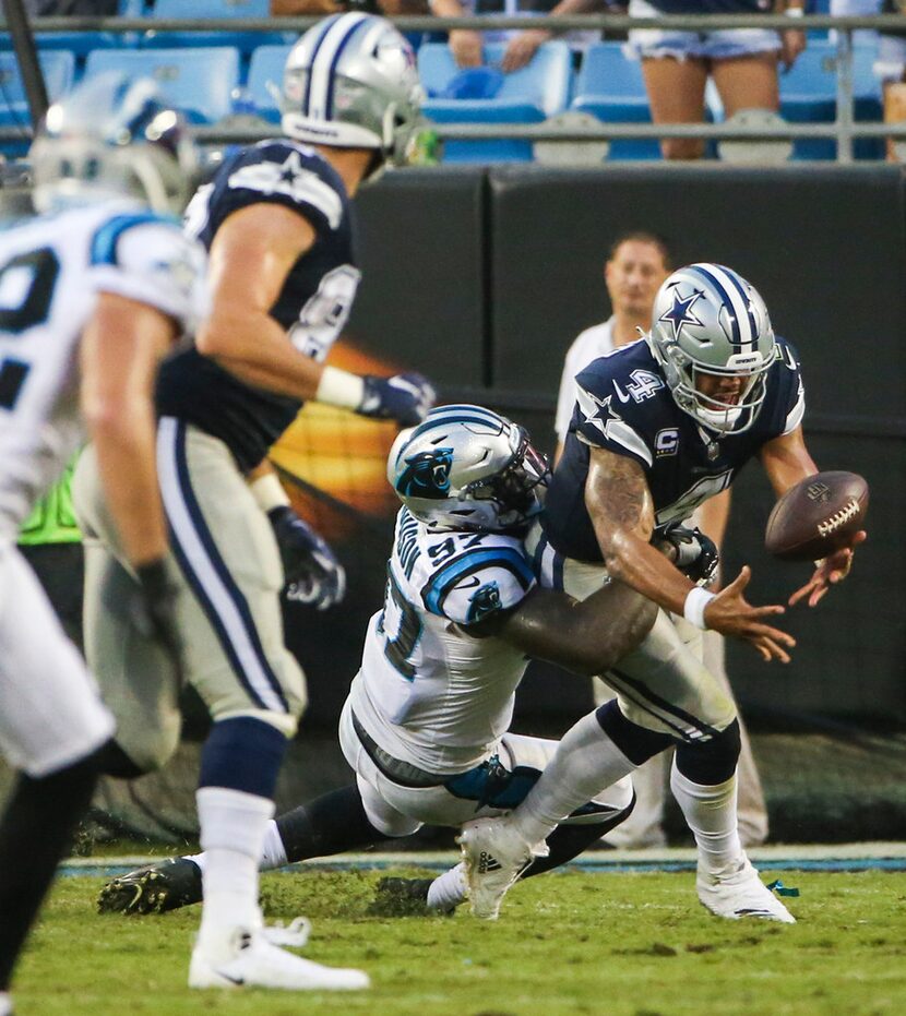 Dallas Cowboys quarterback Dak Prescott (4) fumbles the ball as he is brought down by...