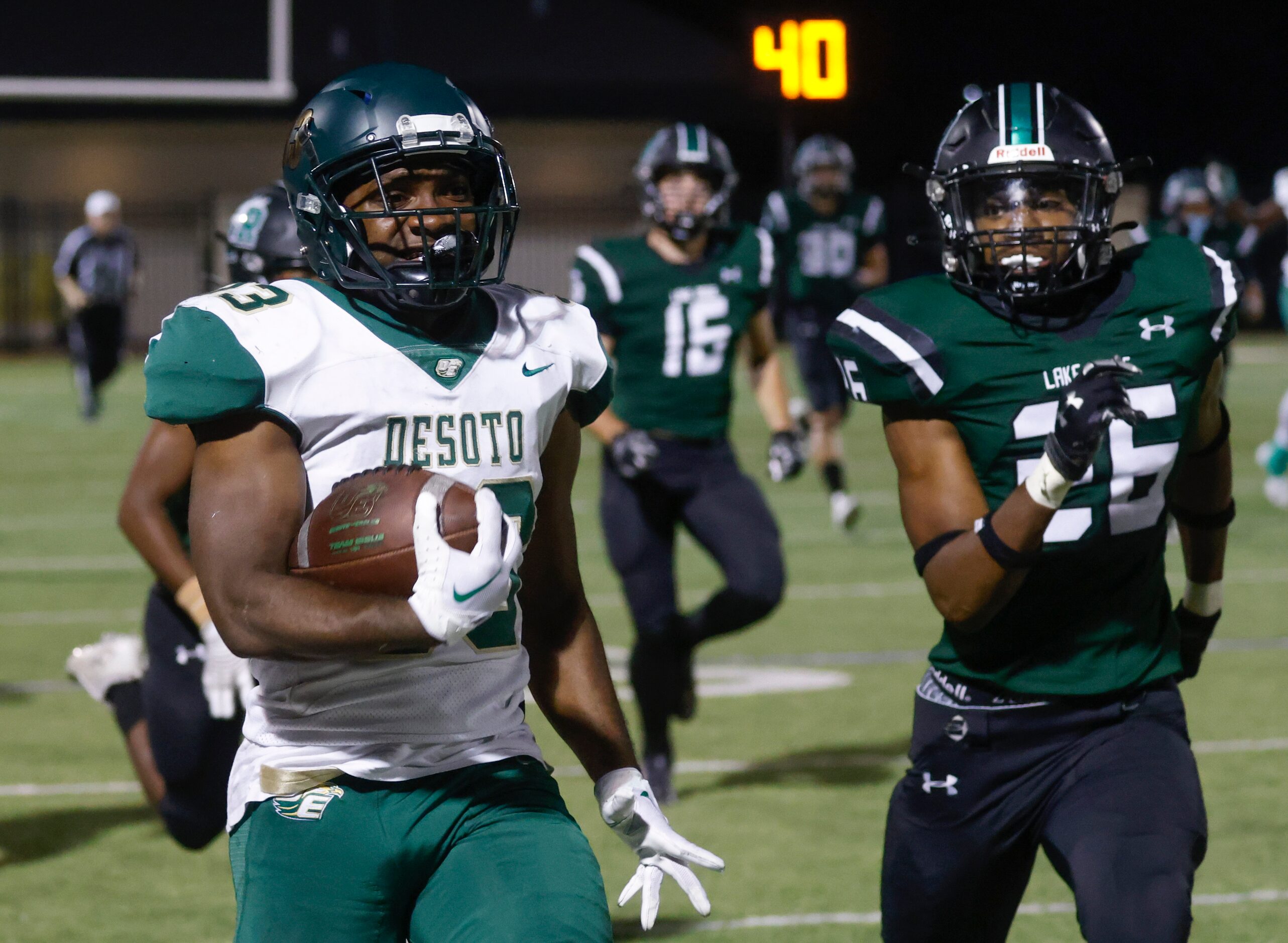 DeSoto High’s Marvin Duffey (33), left, runs for a yardage past Lake Ridge’s Donovan Browder...