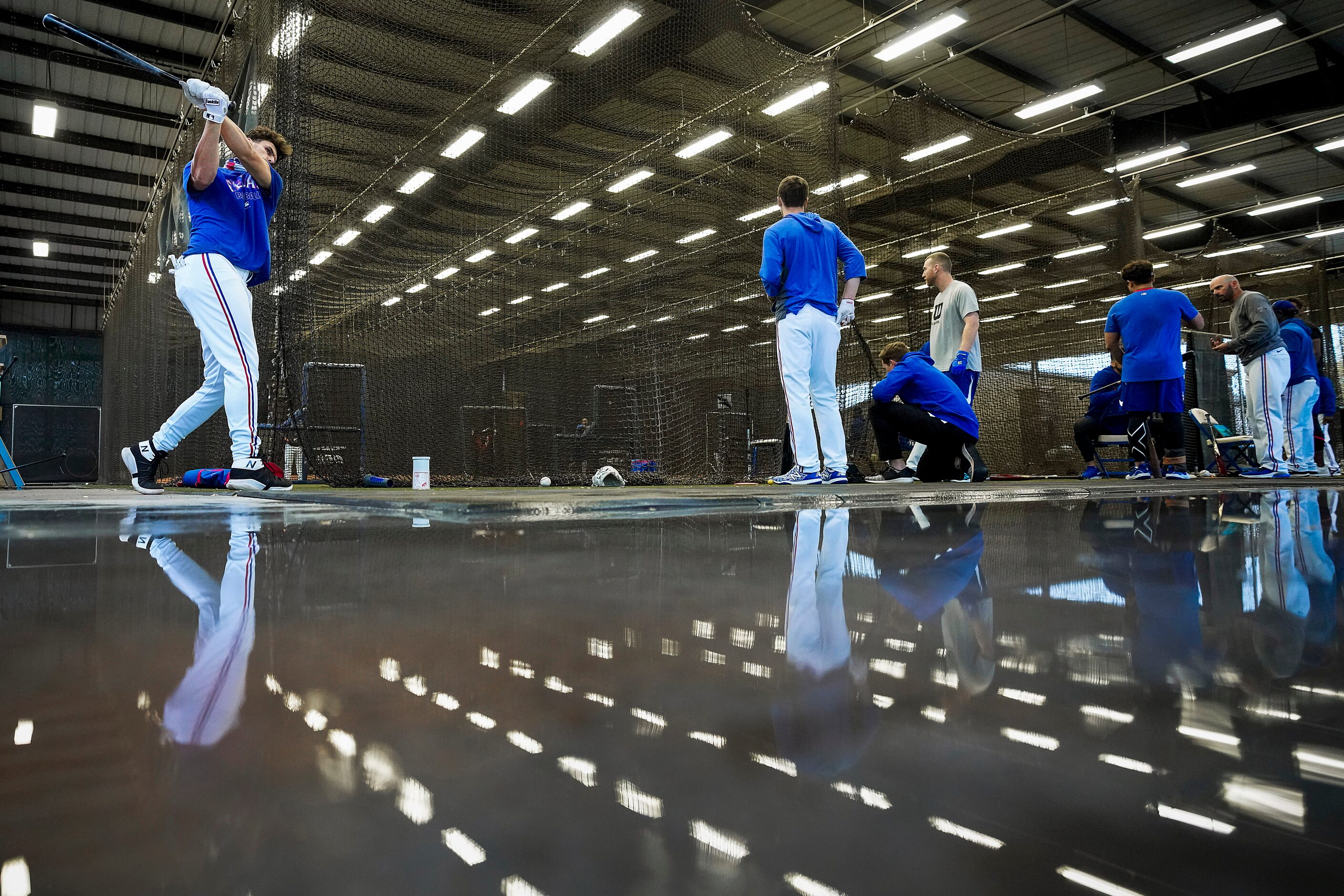 Texas Rangers infielder Greg Bird takes a practice swing in the indoor batting cage during a...