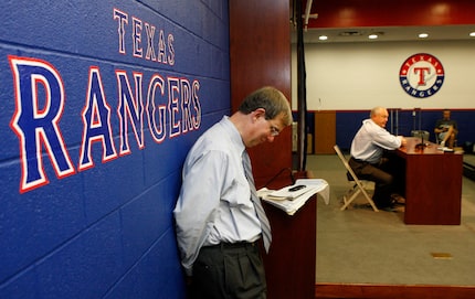 John Blake, Executive Vice-President of Communicatons for the Texas Rangers listens as new...