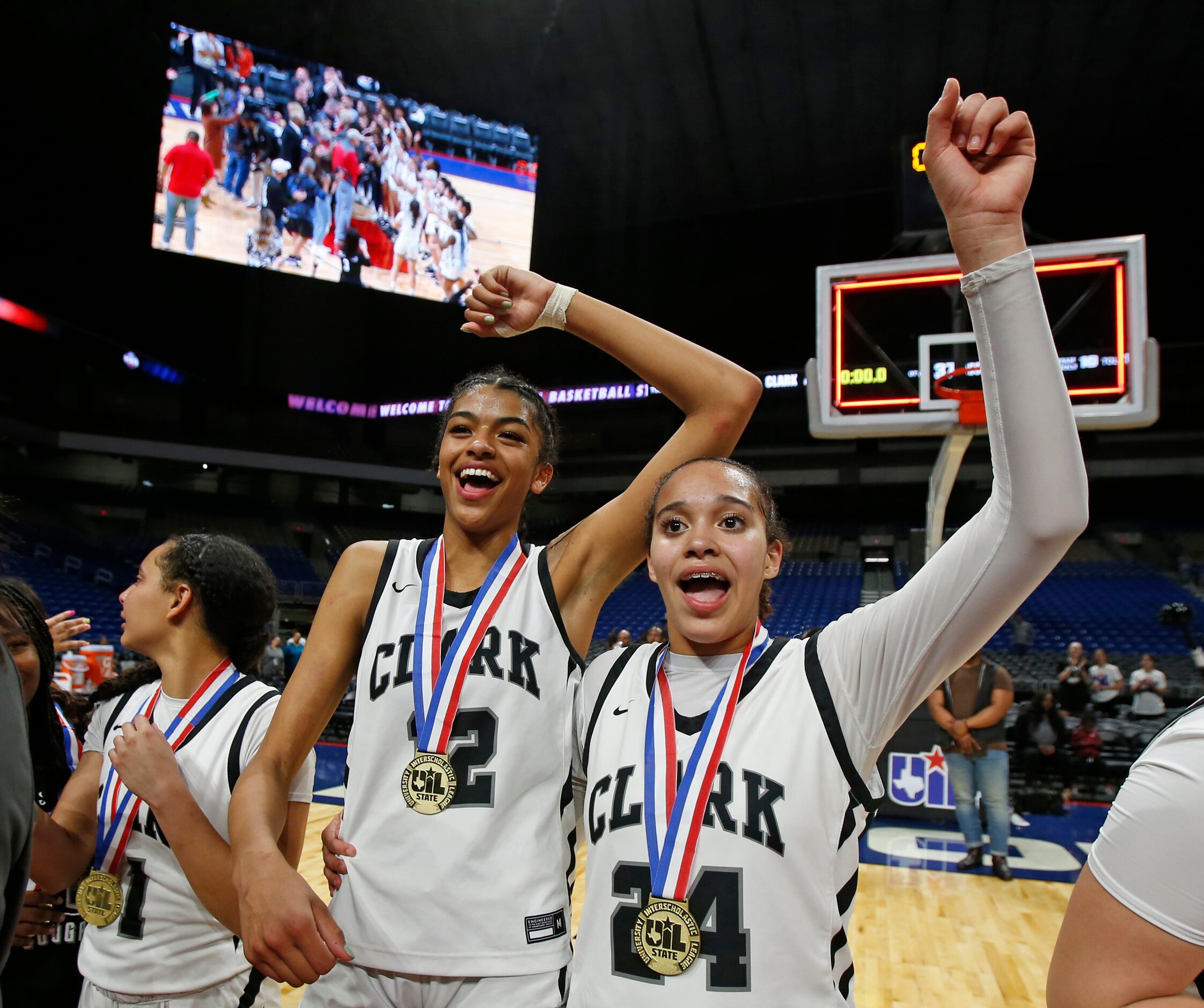 Clark Cougars’ Natalie Huff (1), Adrianna Roberson (12) and Kamryn Griffin (24) react after...