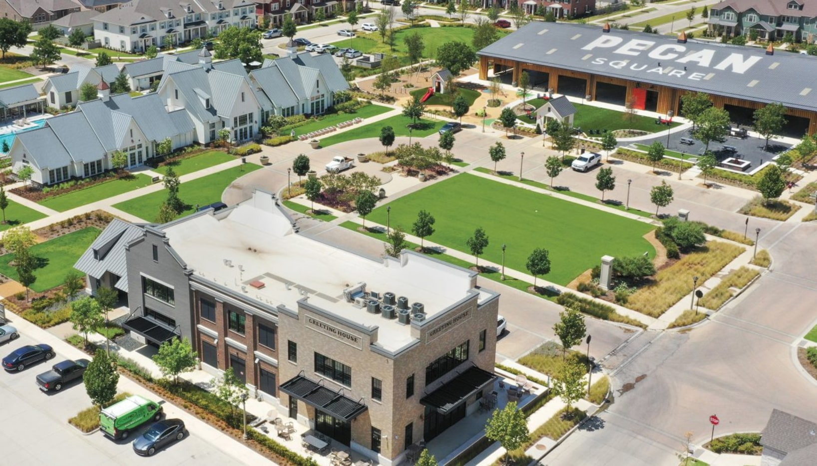 Town square in master-planned community with buildings, houses and green space