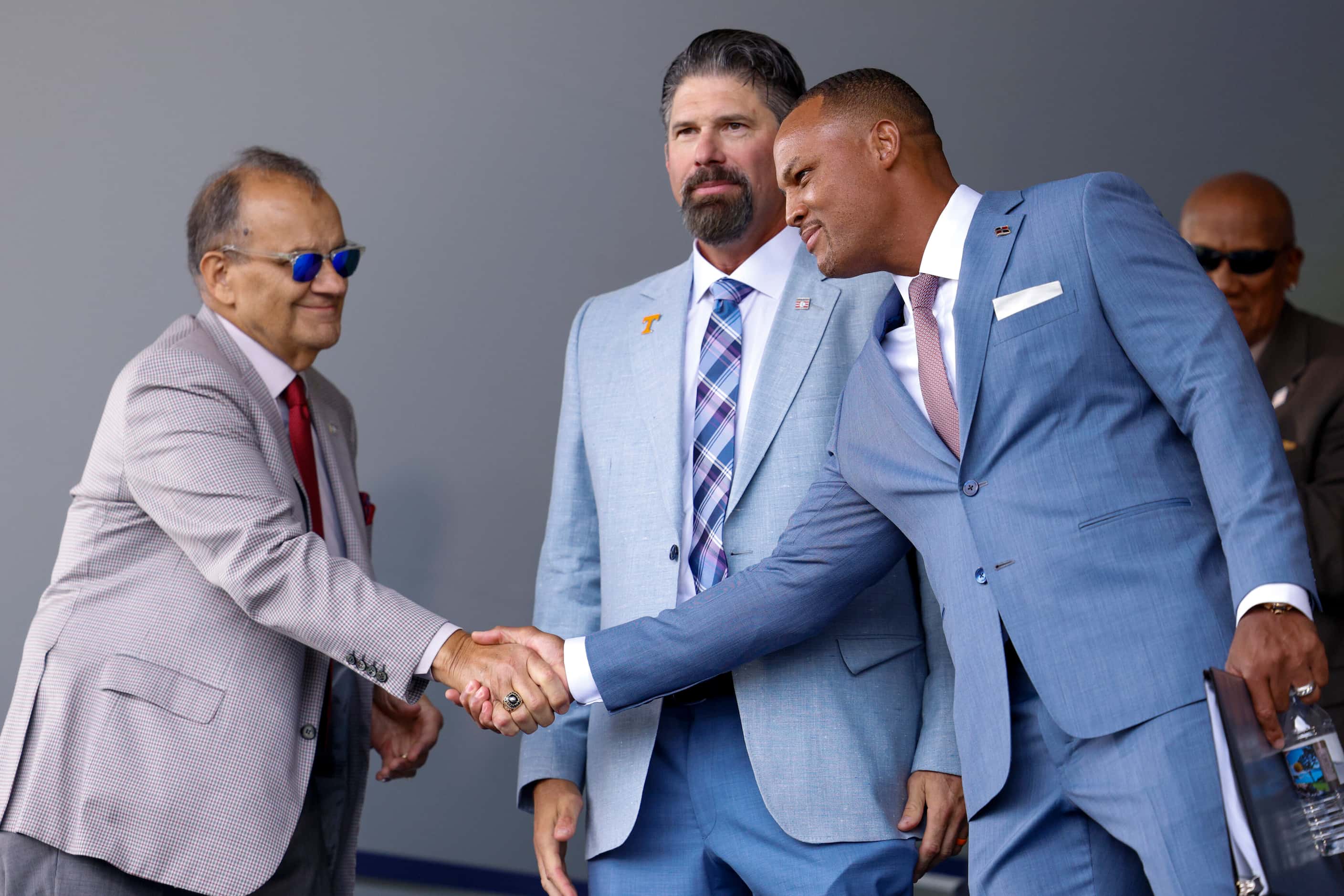 Hall of Famer Joe Torre (left) shakes hands with former Texas Rangers third baseman Adrián...